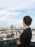 Woman in black blazer standing outside and looking over Vienna's skyline